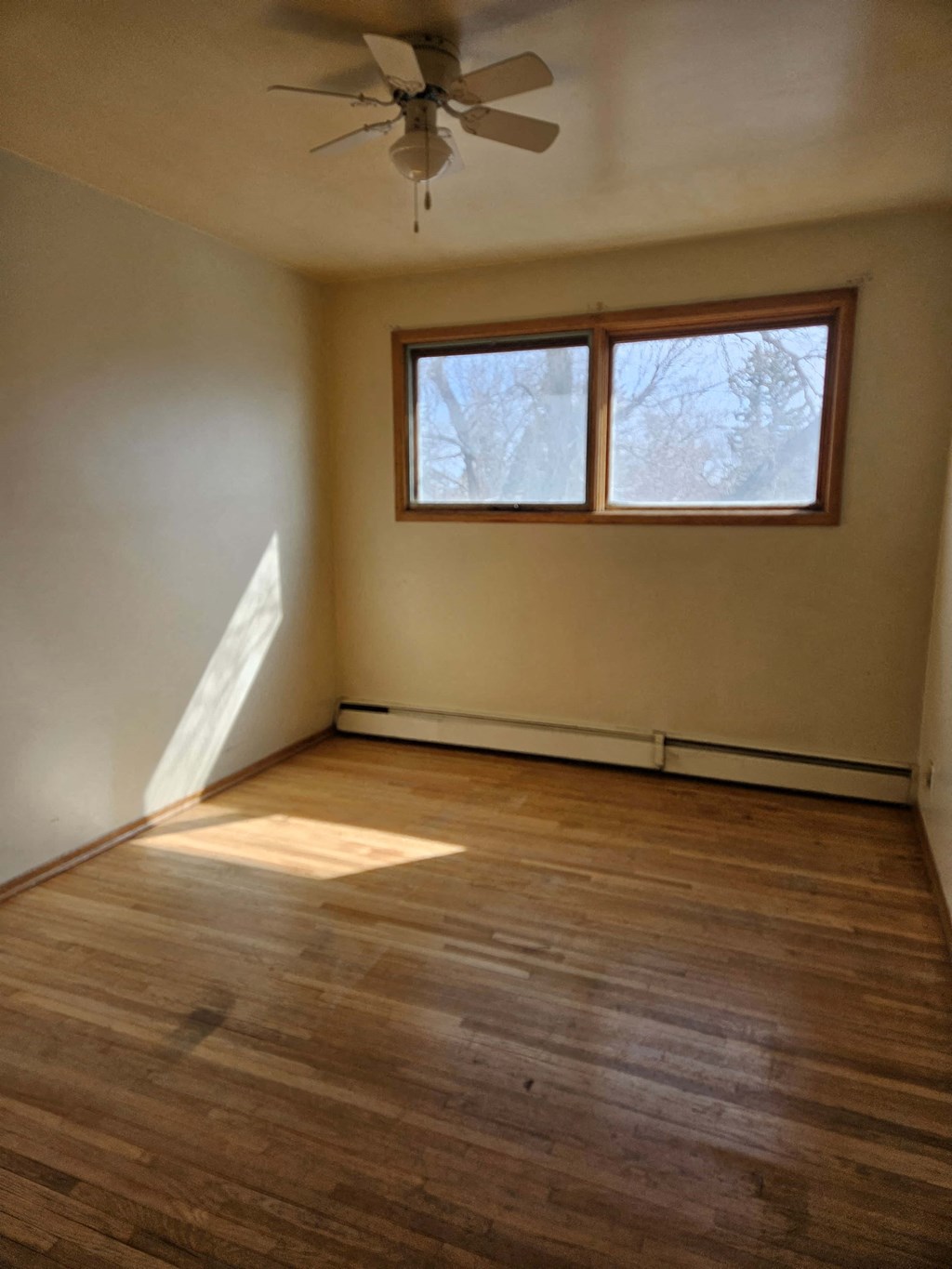 A room with a ceiling fan and a window.