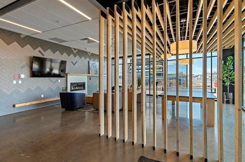 A modern office space with a wood slat partition and a fireplace.