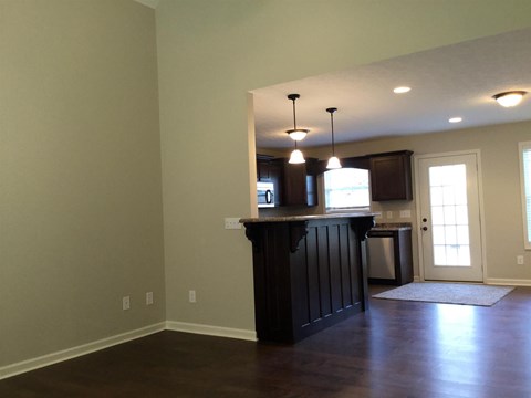 A kitchen with a dark wood counter and a window.