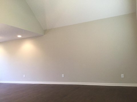 A room with a wooden floor and two lights on the wall.