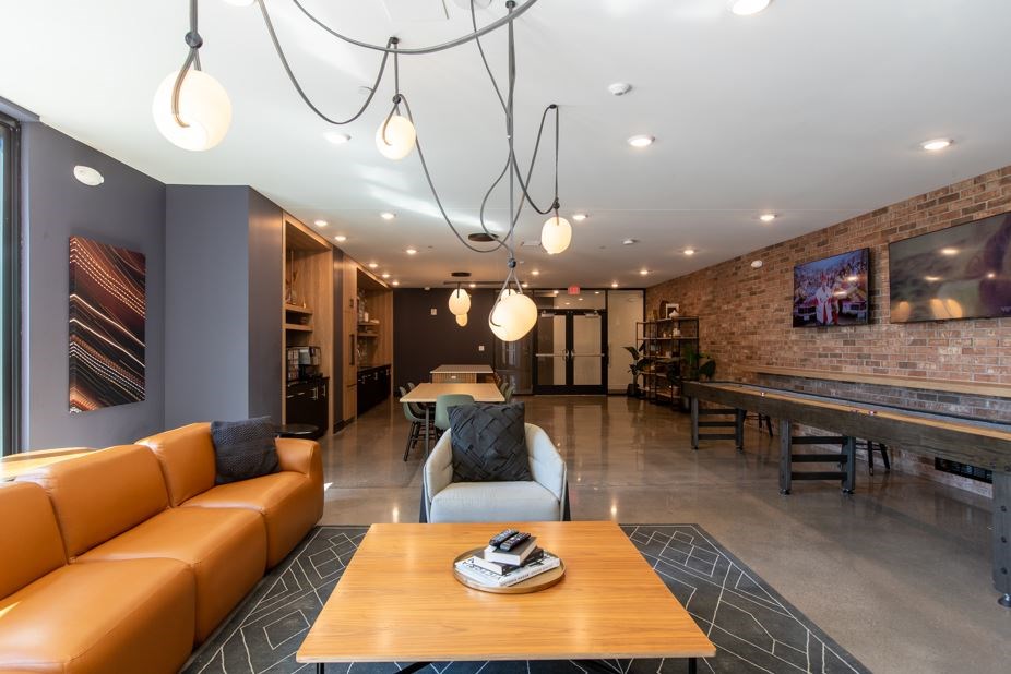 A modern living room with a wooden coffee table and a large orange sofa.