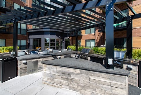 A modern outdoor kitchen area with a bar and seating.