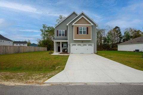 A house with a grey roof and a white garage door.