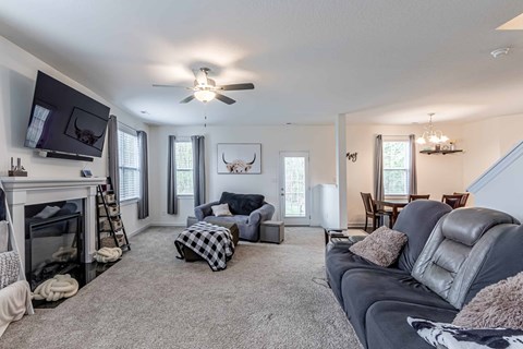 A living room with a grey couch and a fireplace.