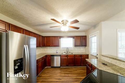 A kitchen with wooden cabinets and a stainless steel refrigerator.