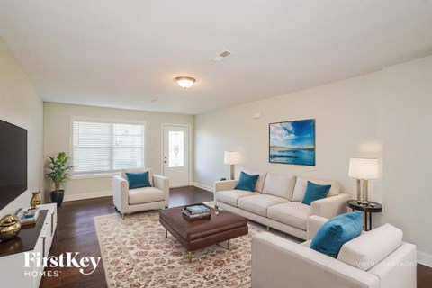 A living room with a white couch, a coffee table, and a painting on the wall.