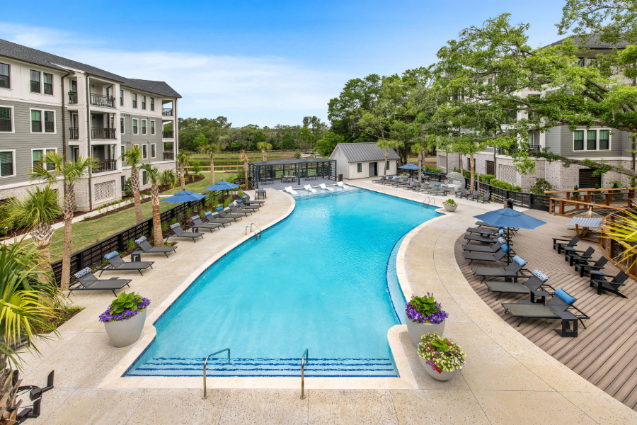 A large swimming pool surrounded by lounge chairs and umbrellas.