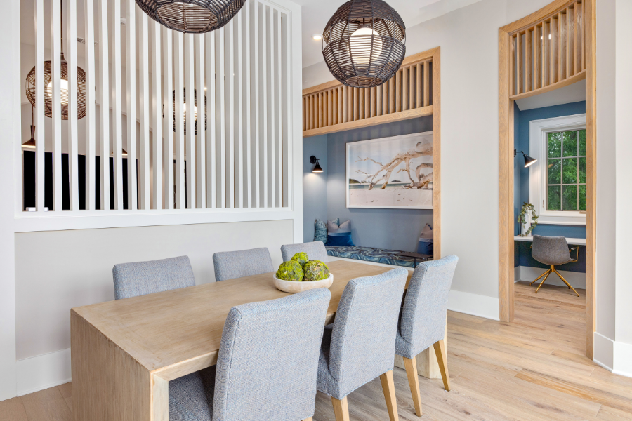 A dining room with a wooden table and grey chairs.