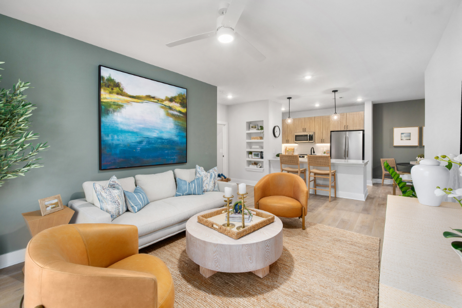 A living room with a painting of a beach scene on the wall.