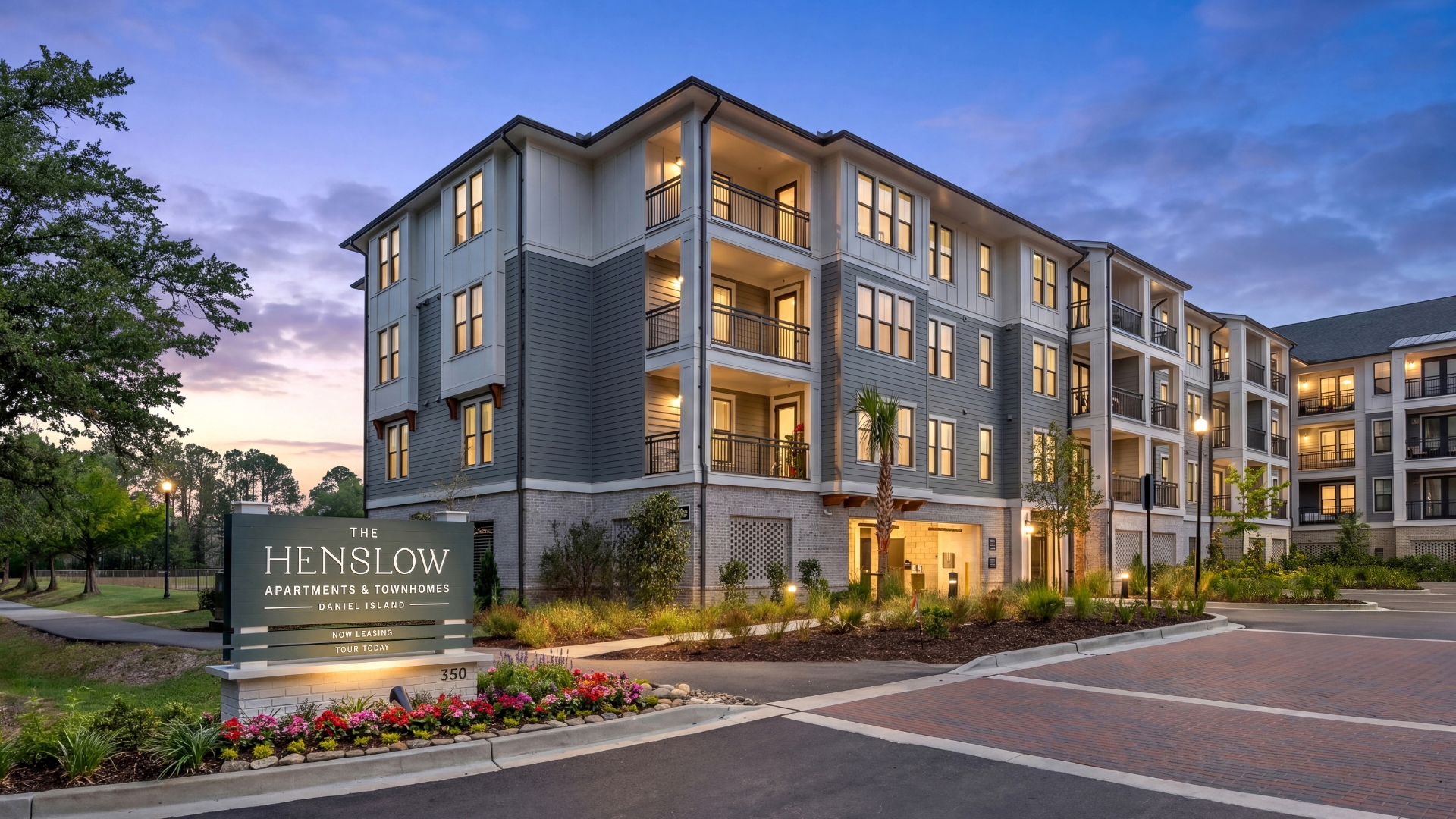The Henslow Apartments building with a sign in front of it.