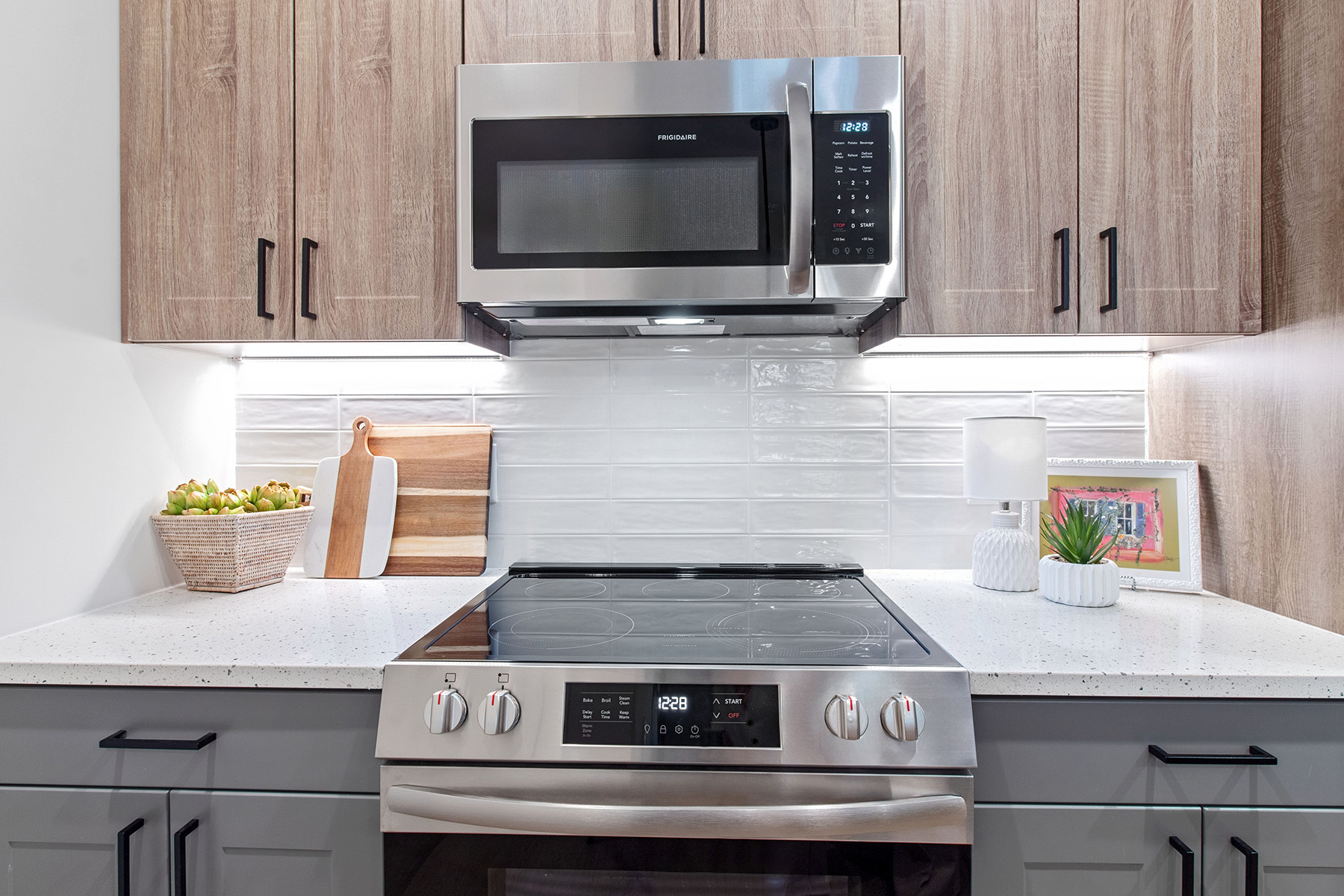 A modern kitchen with a stove top oven and microwave above it.