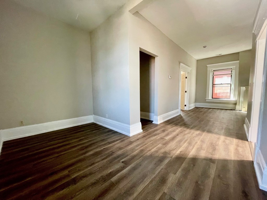 A room with wooden flooring and a window.