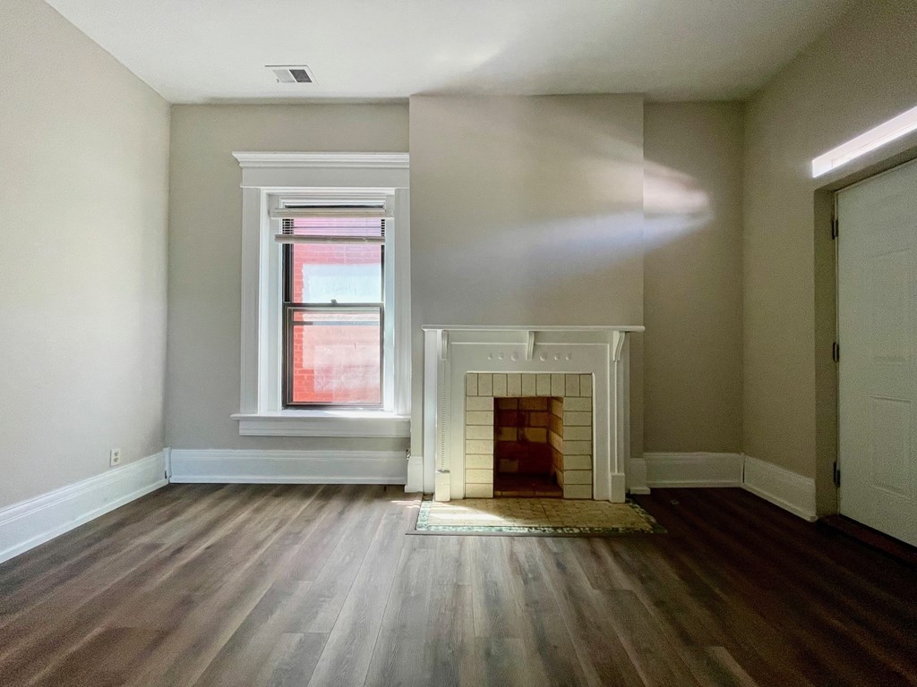 A room with a fireplace and a window.