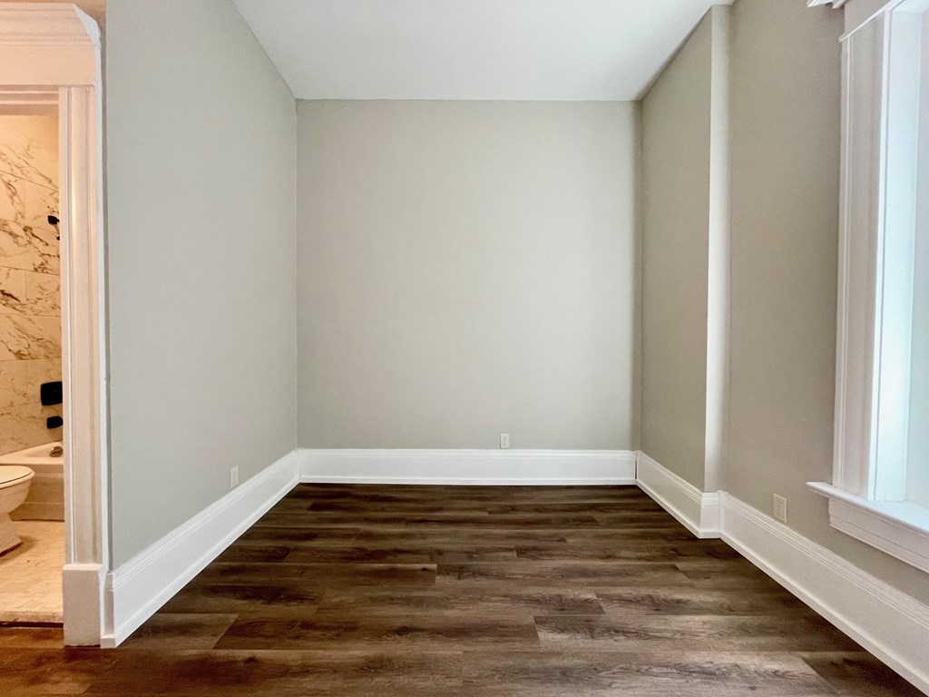 A room with a wooden floor and white walls.
