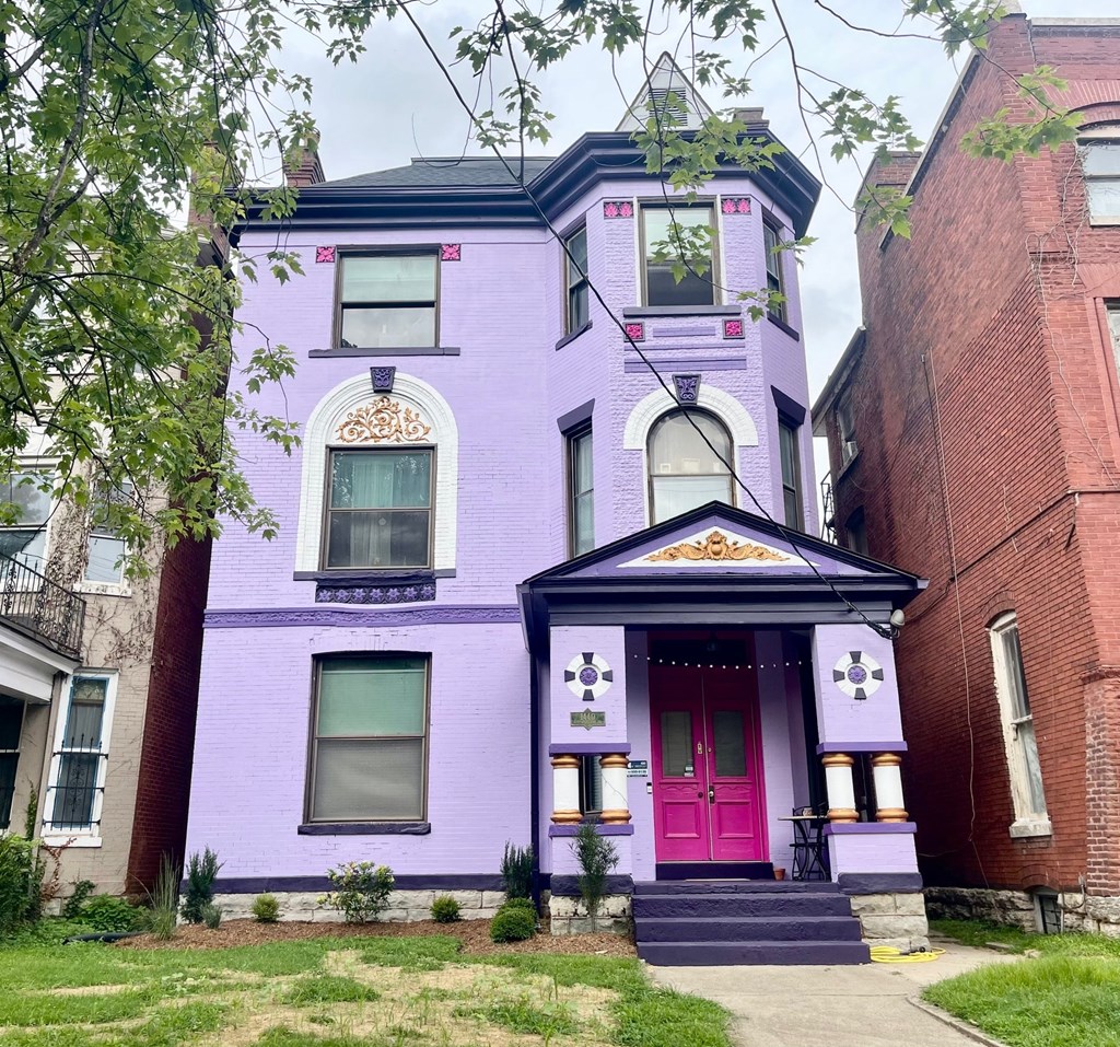 A purple house with a red door and a small porch.