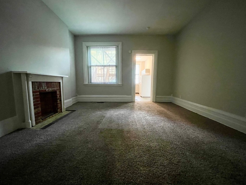A room with a fireplace and a window.