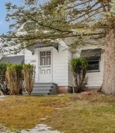 A white house with a grey door and a small porch.