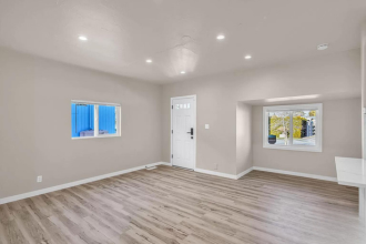 A room with a white door and a window with blue curtains.