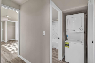 A white refrigerator is in a room with a white door.