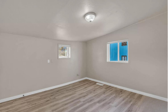 A room with a window and a picture on the wall.