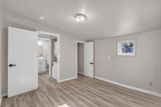 A room with a white door and a picture on the wall.