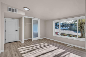 A sunny room with a white door and a window.