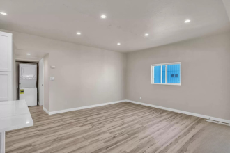 A room with a white door and a window with blue curtains.