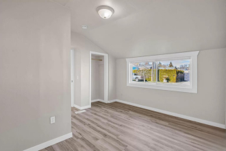 A room with a window and a painting on the wall.