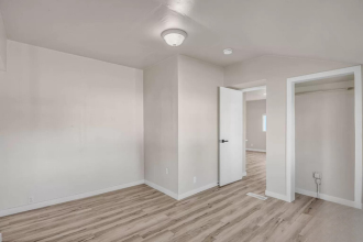 A room with wooden flooring and white walls.