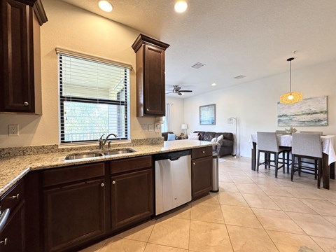 A kitchen with brown cabinets and a white dishwasher.