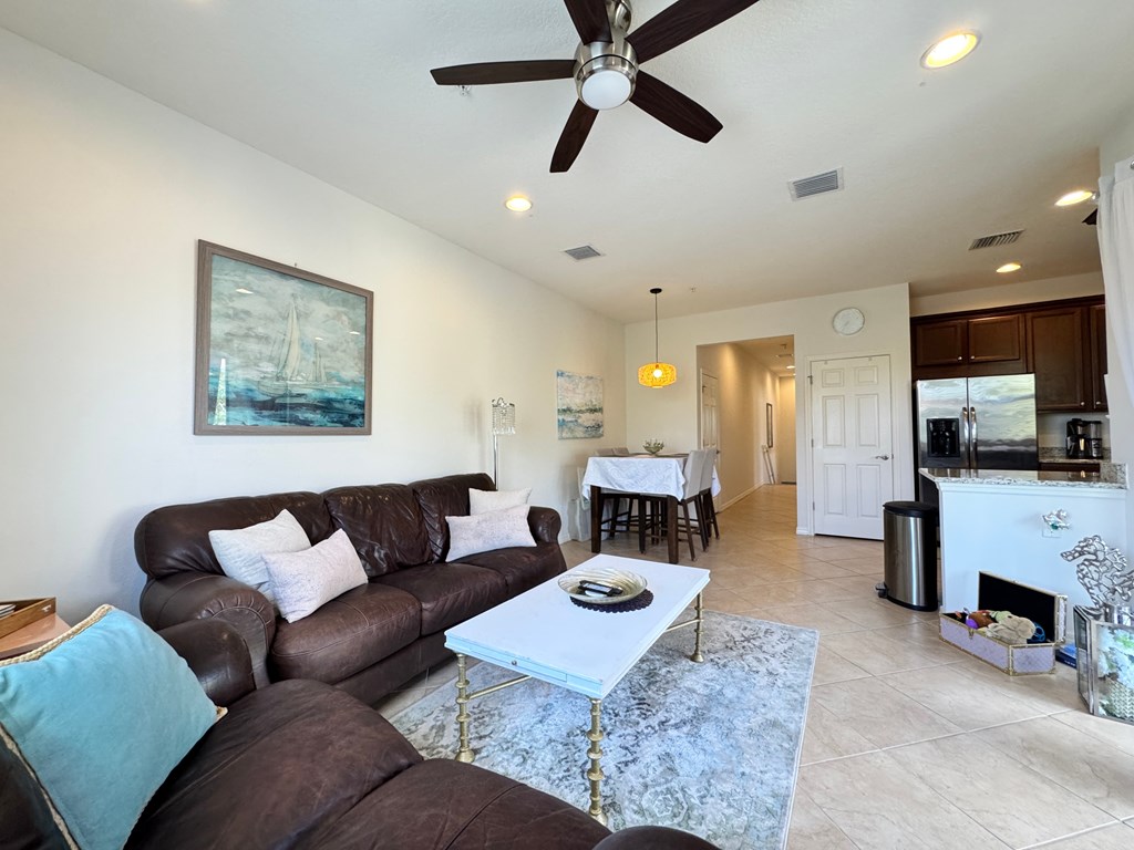 A living room with a brown couch and a white coffee table.