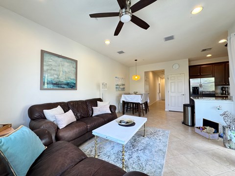 A living room with a brown couch and a white coffee table.