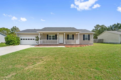 A house with a grey roof and a white garage door.