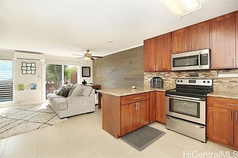 A kitchen with wooden cabinets and a stove top oven.