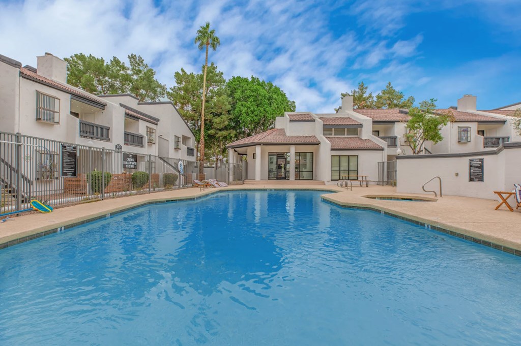A swimming pool in front of a row of houses.