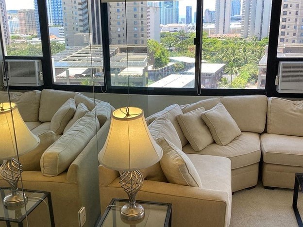 A living room with a large window overlooking a cityscape.