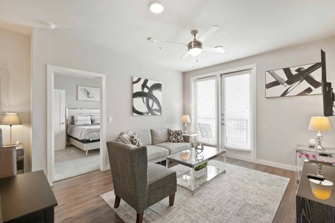 A modern living room with a grey sofa and a glass coffee table.