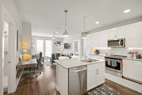 A modern kitchen with white cabinets and a large island.