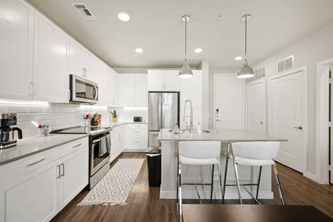 A modern kitchen with white cabinets and a center island.