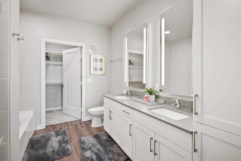 A bathroom with a white toilet, sink, and mirror.