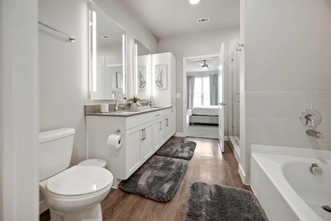 A white bathroom with a toilet, sink, and mirror.