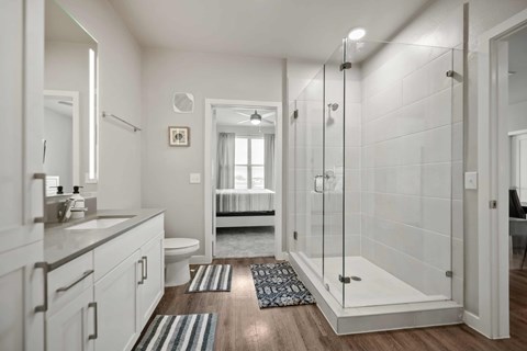 A white bathroom with a walk-in shower and a toilet.