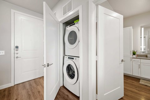 A white laundry room with a washer and dryer built into the cabinetry.