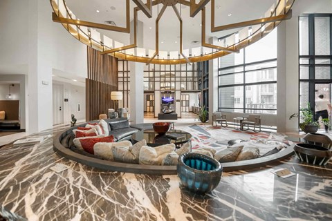 A modern living room with a circular marble table in the center.