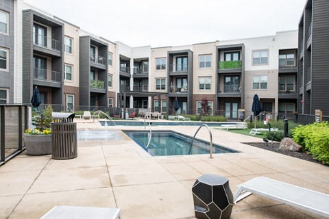 A pool area in front of apartment buildings.