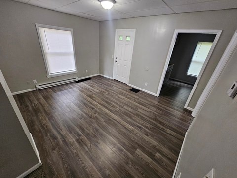 A room with wooden flooring and a white door.