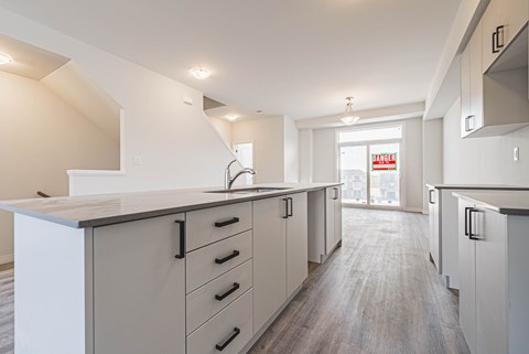 A kitchen with white cabinets and a counter top.