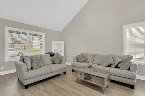 A living room with a grey couch and a wooden coffee table.
