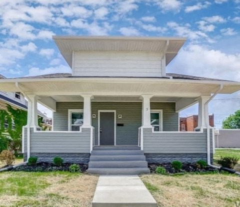A small house with a front porch and a covered front door.