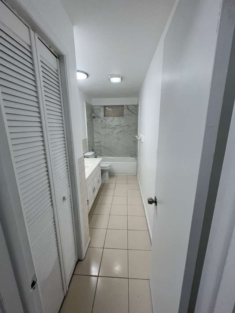 A white bathroom with a white toilet and a white sink.